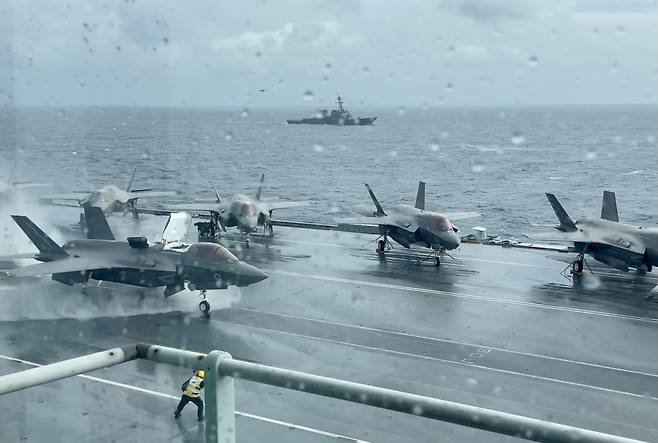 영국 퀸 엘리자베스 항모에서 영국 공군 F-35B 전투기가 비바람이 세차게 몰아치는 가운데 갑판에 고인 빗물을 몰아내며 출격하고 있다. 박용한