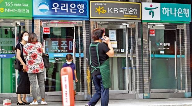 은행 신규 계좌 개설 시 하루 30만원까지만 이체할 수 있도록 한 ‘한도계좌’ 제도가 소비자 불편을 낳고 있다는 지적이 나온다. 서울 광화문의 한 건물 앞에 주요 은행 ATM이 나란히 설치돼 있다.  한경DB