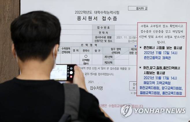 지난 8월 강원 춘천교육지원청에서 한 수험생이 2022학년도 대학수학능력시험(수능) 수험표 교부 안내문을 휴대전화로 찍고 있다. /연합뉴스