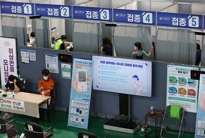 People leave the COVID-19 vaccination center at Bugahyeon Culture and Sports Center on Friday after receiving their vaccine. (Yonhap News)