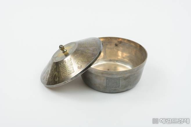 은제이화문합. 뚜껑 손잡이 주변으로 대한제국을 상징하는 오얏꽃 문양이 양각돼 있고, 뚜껑 측면에는 만수무강(萬壽無疆)이라고 쓰여있다. [서울공예박물관 제공]