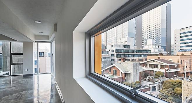 지상 1층 벽면은 전면도로에서 바로 진입할 수 있게끔 폴딩도어로 마감하고(위쪽), 2층의 창문은 주변 건물과 사생활 간섭이 일어나지 않도록 길고 좁은 형태로 만들었다(아래쪽).