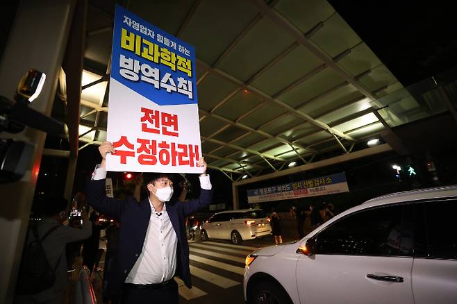 전국자영업자비대위가 코로나19 방역지침 전환을 요구하며 차량시위를 나선 9일 새벽 여의도공원 인근에서 국민의힘 이준석 대표가 방역수칙 수정 손팻말을 들고 있다. 연합뉴스