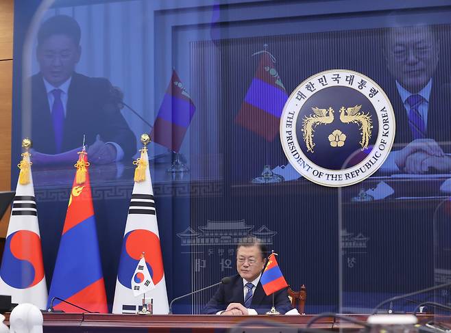 President Moon Jae-in attends a virtual summit with his Mongolian counterpart, Ukhnaagiin Khurelsukh (on screen), at Cheong Wa Dae on Friday. (Yonhap)
