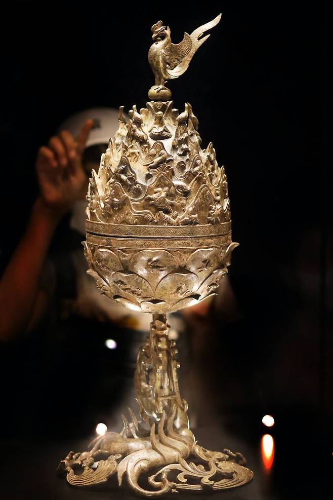 A Phoenix sits on top of the Gilt-bronze Incense Burner of Baekje, Korea’s National Treasure No. 287, which features the world of enlightenment on a lotus flower base blooming from the mouth of a five-legged dragon. The incense burner clearly features animals from distant places, not indigenous to Korea, an example of the far reach of the Baekje Empire’s maritime presence and the empire’s 22 “damro” vassal states.　Photo © 2020 Hyungwon Kang