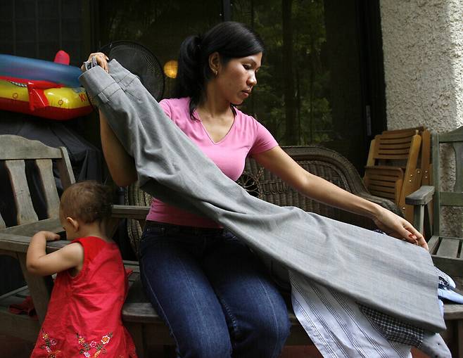 A domestic worker from the Philippines fold laundry at her employer’s home in Singapore. (Reuters)