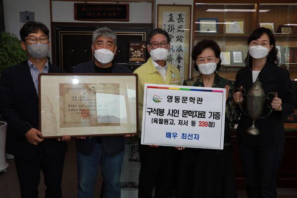 남편의 육필원고 등을 영동군에 기증한 최선자(오른쪽 두번째)씨가 군 관계자 등과 사진을 찍고 있다. 영동군 제공