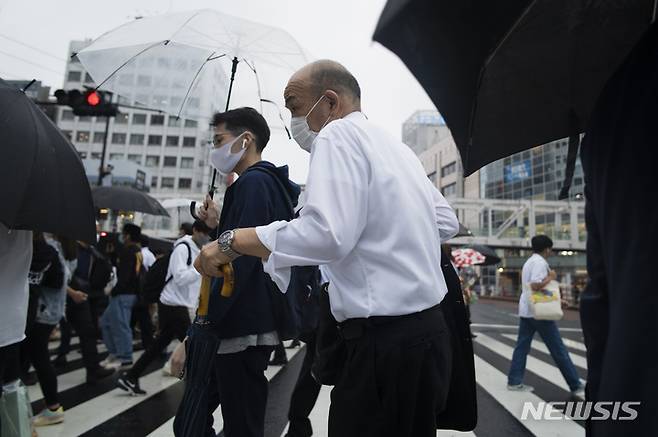 [도쿄=AP/뉴시스] 2일 일본 도쿄에서 코로나19 확산 방지를 위해 마스크를 쓴 시민들이 건널목을 건너고 있다. 2021.09.02