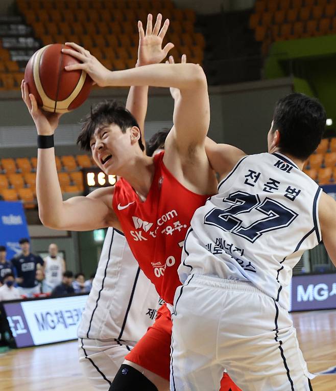 SK의 이원대(가운데)가 13일 열린 2021 KBL 컵대회 KCC와의 경기에서 상대 수비의 마크를 뚫고 슛을 시도하고 있다. 상주/연합뉴스