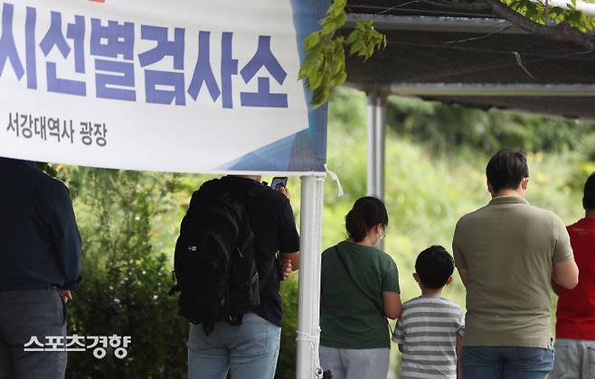서울 마포구 서강대역 선별 진료소에 시민들이 코로나19 검사를 받기 위해 줄 서있다. 아이와 함께 검사 받으러 온 시민들이 눈에 띈다. 13일 0시 기준 신규 확진자는 1433명이다.  한수빈 기자