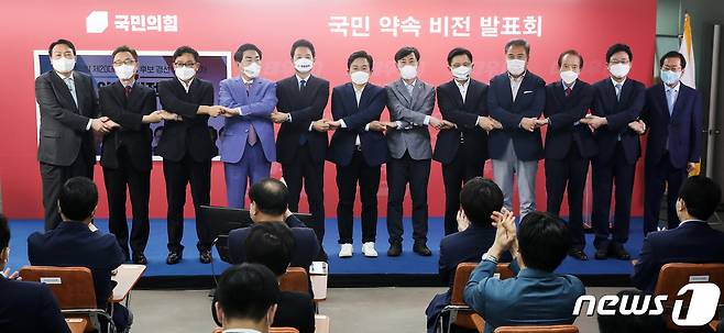 국민의힘 대선 예비후보들이 25일 여의도 당사에서 열린 ‘국민 약속 비전 발표회’에 앞서 손을 맞잡고 기념촬영을 하고 있다. 왼쪽부터 윤석열, 최재형, 박찬주, 안상수, 장성민, 원희룡, 하태경, 황교안, 박 진, 장기표, 유승민, 홍준표 예비후보. 2021.8.25/뉴스1 © News1 오대일 기자