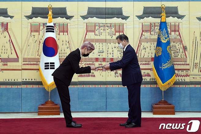 문재인 대통령이 14일 청와대에서 열린 미래세대와 문화를 위한 대통령 특별사절 임명장 수여식에서 아이돌 그룹 방탄소년단(BTS) 멤버 제이홉(정호석)에게 임명장을 수여하고 외교여권과 기념품을 전달하고 있다. 2021.914/뉴스1 © News1 유승관 기자