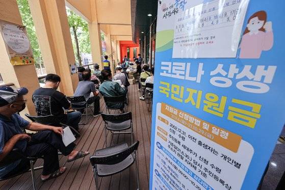 신종 코로나바이러스 감염증(코로나19) 상생 국민지원금 대면 신청 첫날인 13일 오전 서울 동작구 대방동 주민센터를 찾은 주민들이 지역사랑 선불카드를 받기 위해 대기하고 있다. 연합뉴스