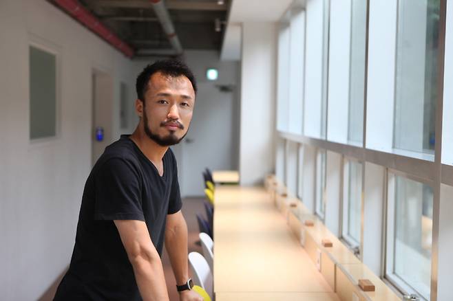 Kang Min, CEO of web development firm Godzebe, poses for a photo after an interview with The Korea Herald at his coworking space in Seoul. (Park Ga-young/ The Korea Herald)