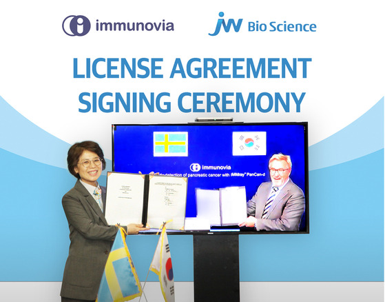 Hahm Eun-kyung, left, CEO of JW Bioscience, and Patrik Dahlen, CEO of Immunovia AB, pose for a photo after signing an agreement online to license the Korean company’s technology to detect pancreatic cancer. [JW BIOSCIENCE]