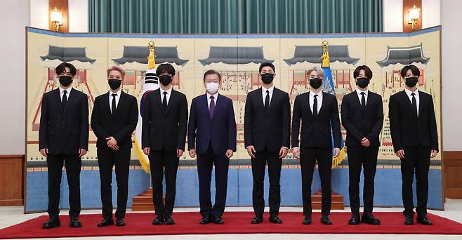 문재인 대통령이 14일 청와대에서 열린 ‘미래세대와 문화를 위한 대통령 특별사절 임명장 수여식’에서 그룹 BTS에게 임명장을 수여하고 기념사진을 촬영하고 있다. 왼쪽부터 뷔, 제이홉, 진, 문 대통령, RM, 슈가, 지민, 정국. [연합]