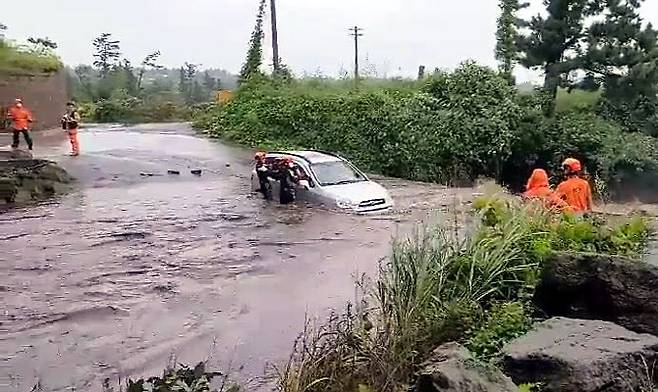 태풍 찬투의 간접 영향으로 제주에 많은 비가 내린 14일 오전 소방대원들이 물에 잠긴 제주시 용강동의 한 도로에서 고립된 차 안의 운전자를 구조하고 있다. (사진=연합뉴스)