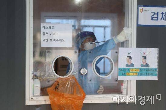 수도권을 중심으로 코로나19 확산세가 거세지고 있는 15일 서울역 광장에 마련된 임시 선별검사소에서 의료진이 유리벽을 소독하고 있다. /문호남 기자 munonam@