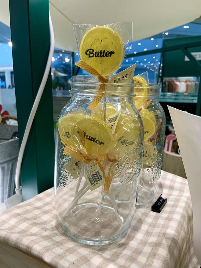 BTS-themed lollipops named after the band’s megahit song “Butter” are displayed inside a glass bottle. (Park Jun-hee/The Korea Herald)