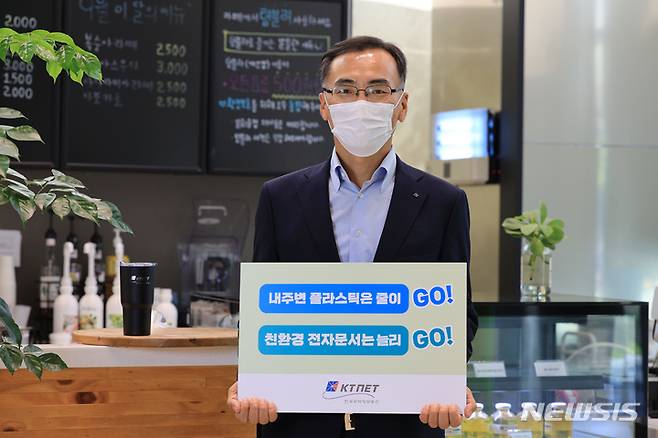 [서울=뉴시스] 차영환 한국무역정보통신(KTNET) 사장이 15일 사내 카페에서 '고고 챌린지' 캐치 프레이즈 피켓을 앞에 두고 캠페인에 동참했다.(사진=한국무역정보통신 제공) 2021.9.15 photo@newsis.com
