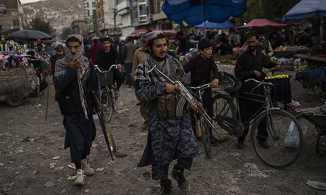 14일(현지시간) 탈레반 병사들이 아프가니스탄 카불의 한 시장을 순찰하고 있다. 미국과 나토가 아프간에서 철수하고 탈레반이 점령하면서 아프간은 경제 붕괴와 식량난으로 어려움이 더욱 늘어날 것으로 우려된다. 카불=AP뉴시스