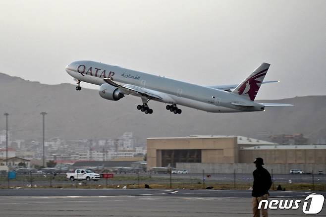 미국인 등 승객 200명을 태운 카타르 항공기가 9일(현지시간) 아프가니스탄 카불 공항을 이륙하는 중 보안 요원들이 경비를 서고 있다. 지난달 30일 밤 11시59분 마지막 미 군 수송기가 떠난 이후 첫 탈출 비행이다. © AFP=뉴스1 © News1 안은나 기자