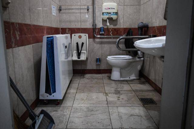 서울 영등포구 여의도역 인근 한 건물의 남녀공용 장애인 화장실 풍경. 우산빗물제거기와 청소 도구가 어수선하게 놓여 있다.