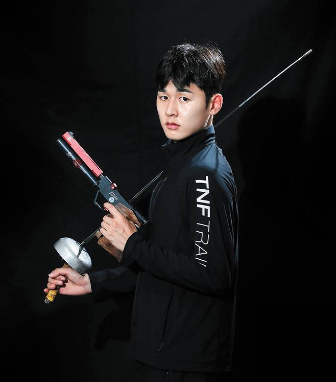 도쿄올림픽 근대 5종 동메달리스트 전웅태. 양손에 레이저 런의 총, 펜싱검을 들고 있다. 프리랜서 장정필