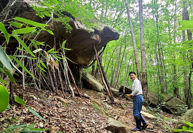 비탈진 산 중턱에 걸린 돌에는 작은 돌탑을 올리지 않고, 지지대 같은 작대기를 세워두는 게 소원을 비는 방법이다. 건강한 삶 속에 동안을 유지한 김정환(67) 신월리 구수마을 이장이 기차산 기슭 큰바위 앞에서 미소짓고 있다.
