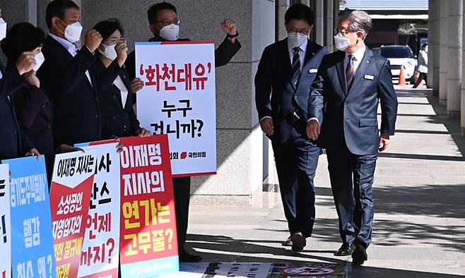 지난 15일 더불어민주당 대선 주자인 이재명 경기지사가 경기도 수원시 경기도의회에서 열린 제354회 임시회 제4차 본회의에 출석하기 위해 청사로 들어서자 국민의힘 소속 경기도의원들이 화천대유 특혜 의혹 수사를 촉구하며 시위를 벌이고 있다. 뉴시스