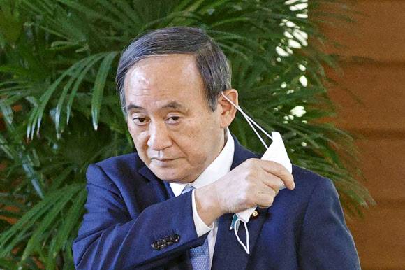 ‘자민당 재보선 전패’ 입장 밝히는 스가 일본 총리 - 스가 요시히데 일본 총리가 26일 도쿄의 총리관저에서 취재진과 만나며 마스크를 벗고 있다. 스가 총리는 이 자리에서 내각 출범 이후 25일 처음 치러진 3곳의 일본 국회의원 재?보궐 선거가 집권 자민당의 전패로 끝난 결과를 심각하게 받아들이고 있다고 밝혔다. 도쿄 AP/교도=연합뉴스