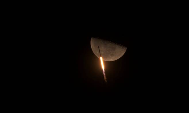 달을 배경으로 날아가는 팰컨9 로켓
