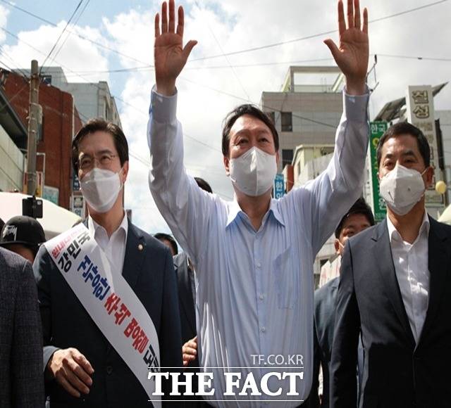 윤 전 총장이 진주중앙시장을 찾아 손을 번쩍 들어 시민들과 인사를 나누고 있다./진주=이경구 기자