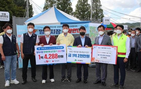 14일 경북 영덕군 영덕읍 영덕시장이 최근 발생한 화재로 폐쇄되면서 인근이 임시시장이 마련됐다. 이철우 경북도지사, 권영진 대구시장 등이 영덕시장 상인들을 위해 성금을 기부하고 기념촬영하고 있다. 사진 대구시