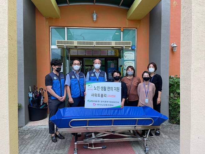 한수원 정보보안처(왼쪽서 세번째 남영규 한수원 정보보안처장)가 16일 경주 하나노인복지센터에 이동식 목욕침대를 전달한 뒤 기념촬영을 하고있다.