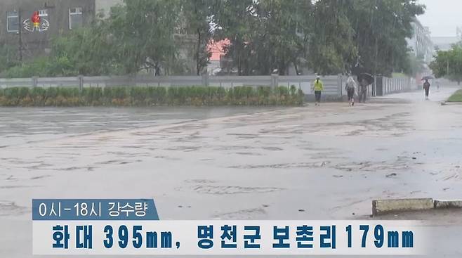 폭우로 물에 잠긴 북한 함북 화대군 도로 - 북한 함경북도 화대군에서 이날 하루에만 395㎜의 폭우가 내렸다고 조선중앙TV가 11일 보도했다. 주민들이 폭우로 침수된 도로를 걷고 있다. 조선중앙TV 캡처 2021.8.11 연합뉴스
