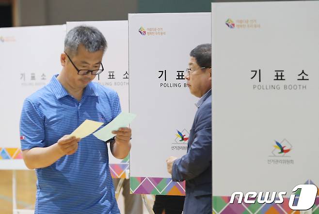 2018년 6·13 지방선거 투표일인 13일 오전 제주시 노형동 한라초등학교에 마련된 연동 제8투표소를 찾은 유권자들이 투표를 하고 있다. 2018.6.13/뉴스1 © News1