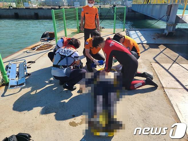 19일 해경이 해상으로 추락한 낚시객을 인양해 심폐소생술을 시도하고 있다(여수해경 제공)2021.9.19/© 뉴스1