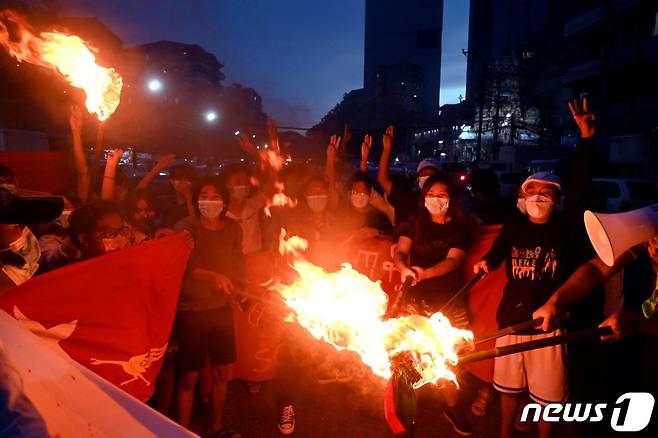 29일(현지시간) 미얀마 양곤에서 열린 군사 쿠데타 반대 시위 도중 시위대가 미얀마 국기를 불태우고 있다. © AFP=뉴스1 © News1 서한샘 기자