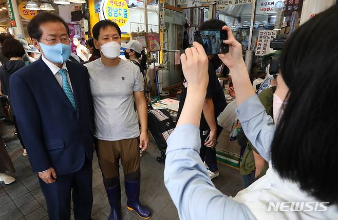 [서울=뉴시스] 배훈식 기자 = 국민의힘 대선주자 홍준표 의원이 19일 오후 서울 송파구 잠실 새마을 전통시장을 방문해 추석 연휴를 맞은 상인들과 기념촬영을 하고 있다. 2021.09.19. dahora83@newsis.com