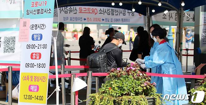 추석 연휴 셋째 날인 20일 오전 서울 중구 서울역 선별진료소에서 의료진과 근무자들이 검사를 받기 위해 온 시민들을 안내하고 있다. 질병관리청 중앙방역대책본부는 20일 0시 기준 신종 코로나바이러스 감염증(코로나19) 신규 확진자가 전날 대비 305명 감소한 1605명 발생했다고 밝혔다. 전날(1천910명)보다 305명 줄었으나, 일요일 확진자(발표일 기준 월요일)로는 국내 코로나19 사태 이후 최다 기록이다.2021.9.20/뉴스1 © News1 김진환 기자