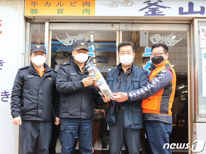 지난 3월5일 부산 의용소방대원들이 중구 일대 음식점에 'K'급 소화기를 전달했다.(부산소방재난본부 제공) © 뉴스1
