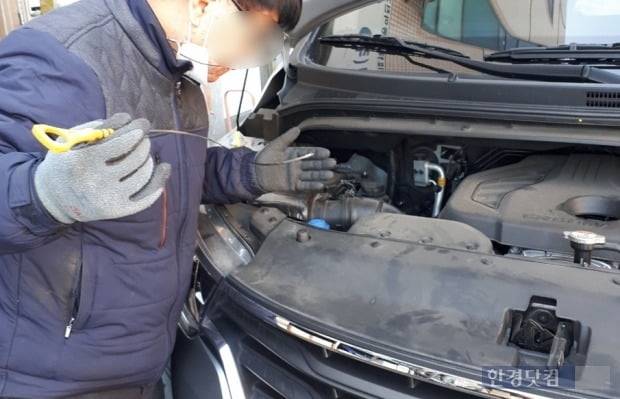 한 차량 정비사가 딥스틱을 꺼내 엔진오일 상태를 확인중이다./ 사진=신현아 한경닷컴 기자