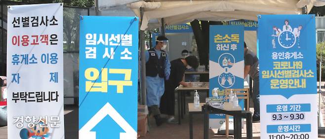 지난 17일 오전 경기도 용인시 영동고속도로 인천방향 용인휴게소 마련된 임시 선별진료소에서 사람들이 검사를 받기위해 문진표를 작성하고 있다. 김기남 기자