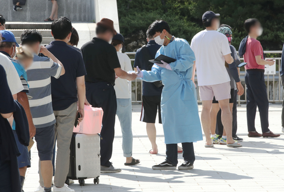 People stand in line to get Covid-19 tests at a screening station at Suseo Station in southern Seoul on Wednesday, the last day of the Chuseok holiday. [YONHAP]