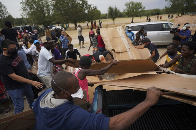 난민촌의 환경을 개선하고자 골판지를 받아 침대를 만드는 아이티 난민 무리. AP뉴시스