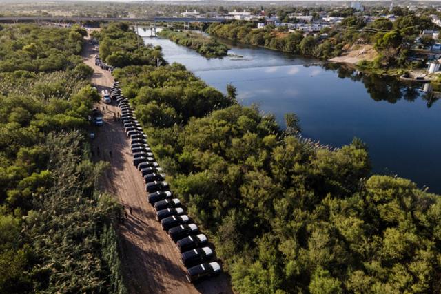 22일 미국 텍사스주 국경 도시 델리오의 리오그란데 강을 따라 수백 대 차량으로 바리케이드가 세워진 모습. AP 연합뉴스