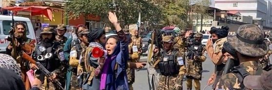 무장한 남성들 사이에서 시위하는 아프가니스탄 여성. 사진 트위터