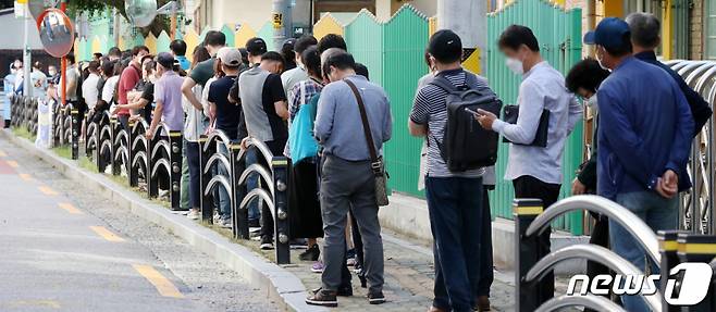 23일 오전 서울 구로구 보건소에 마련된 코로나19 선별진료소에서 시민들을 비롯한 국내 거주 외국인 노동자들이 코로나19 진단 검사를 받기 위해 길게 줄을 서 있다./사진=뉴스1