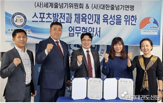 세계줄넘기위원회 김후준 회장(가운데)과 대한줄넘기총연맹 김수잔 회장(오른쪽에서 두번째)이 협약서에 서명한 뒤 기념사진을 찍고 있다.